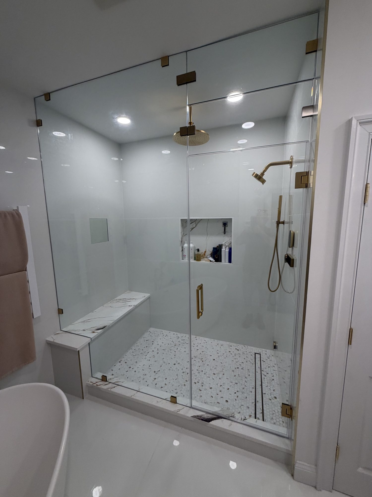 Frameless steam shower enclosure with double transom and brass hardware